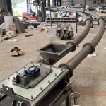 Curved pipe chain conveyor with inlet hopper and drive assembly