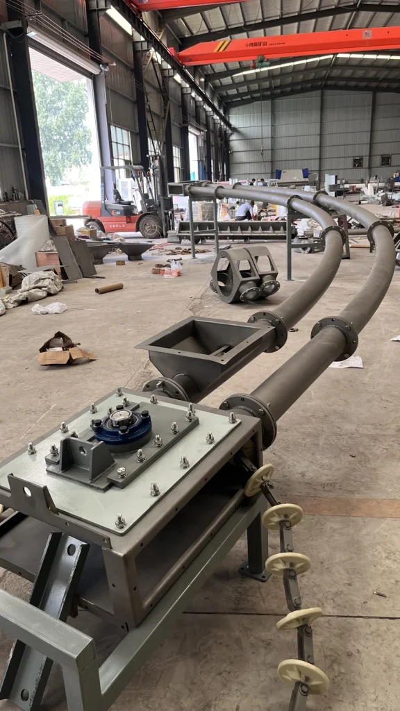 Curved pipe chain conveyor with inlet hopper and drive assembly