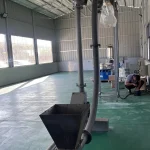 Vertical pipe chain conveyor with a feed hopper and rising tube
